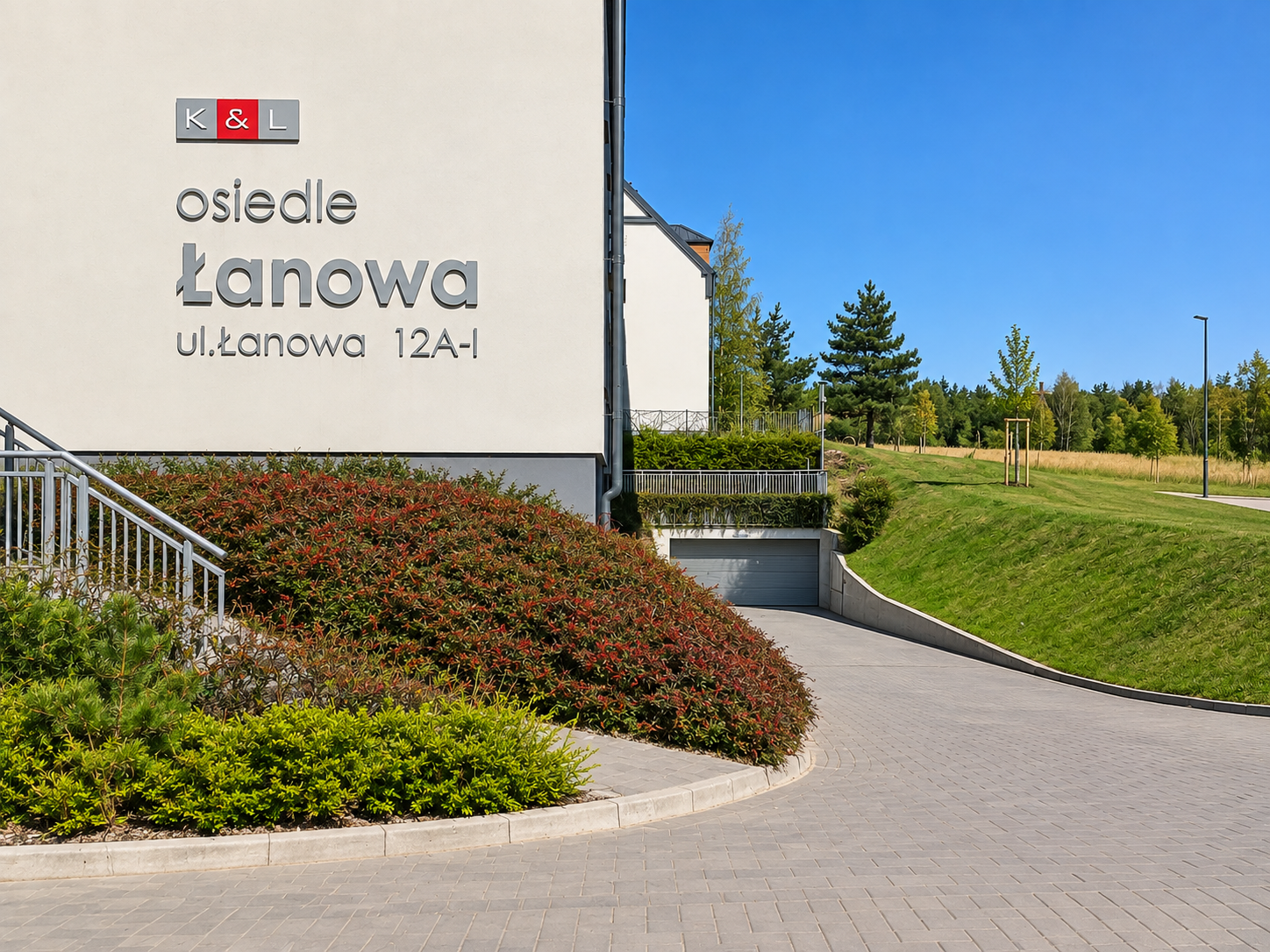 Zadbane trawniki, rabaty i formowane krzewy na osiedlu mieszkaniowym